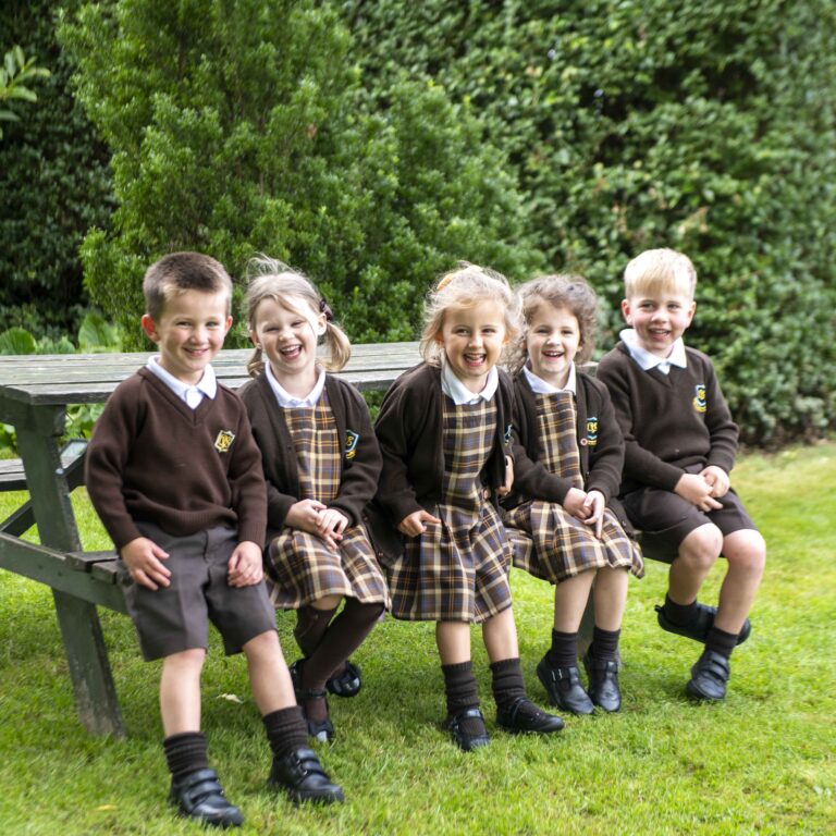 Happy children at the old vicarage school derby sat on a picnic bench