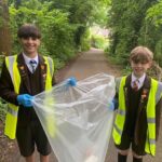 school pupils picking up litter in high vis vest