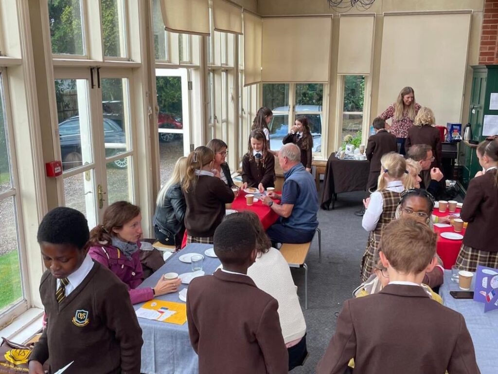 Old Vicarage School pupils serving coffee and croissants in the conservatory