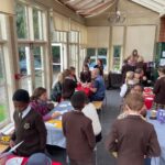 Old Vicarage School pupils serving coffee and croissants in the conservatory