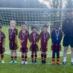 Prep school football team in full kit displaying medals